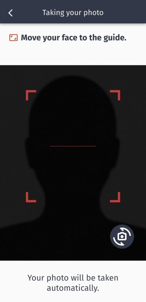 畫面顯示使用者拍照時的App介面,以黑底剪影與紅色框線標示臉部定位區域。上方提示文字「Move your face to the guide」,下方寫明「Your photo will be taken automatically」,說明系統會在臉部對準後自動拍攝。此步驟為NZeTA人臉辨識拍照階段,協助自動生成符合規範的影像。